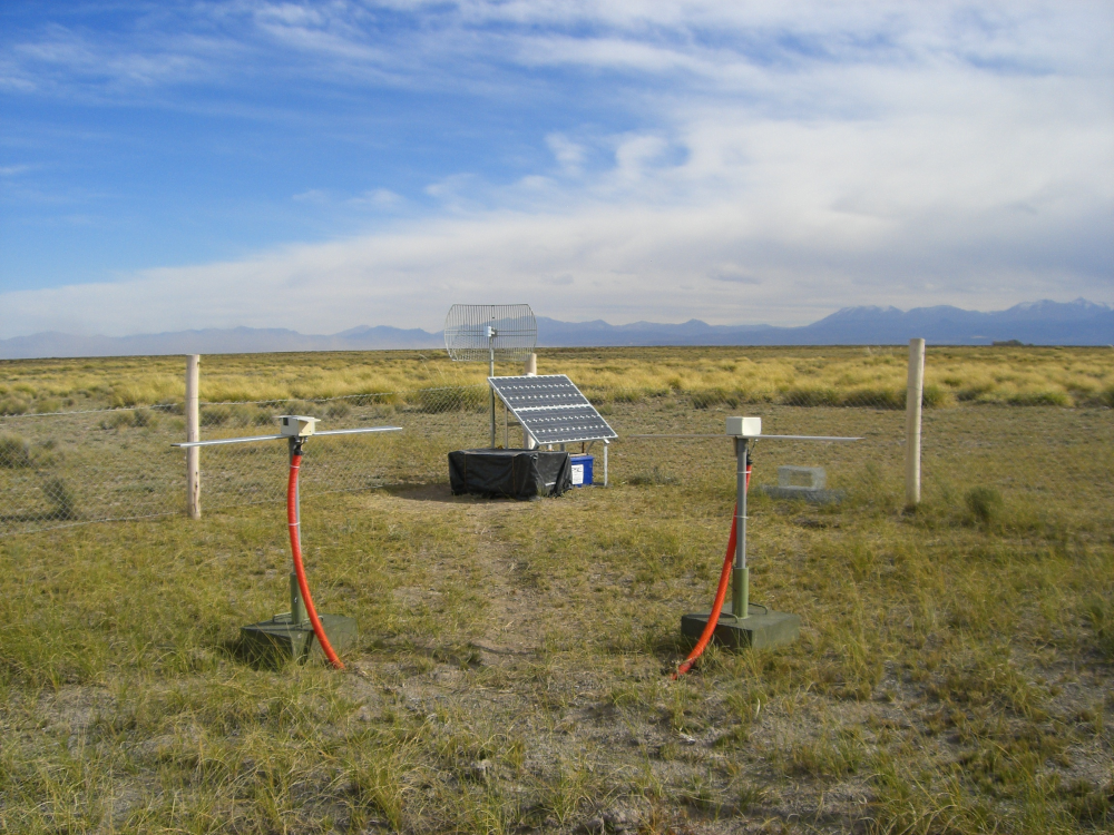 A RAuger-1 radio-detection station with its two dipole antennas and, in the back, the solar panels, the electronics box (covered by a black plastic sheet) and the WiFi antenna pointing toward the CLF.